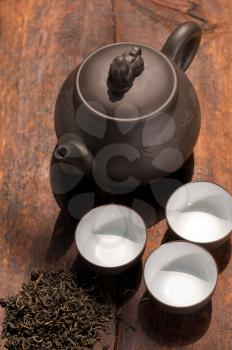 chinese green tea traditional  pot and cups over old wood board 
