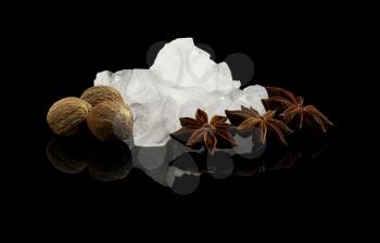 crystal sugar and spice  over black reflective surface background