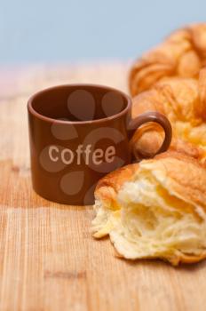 three fresh baked french croissant brioche on wood board and coffee cup