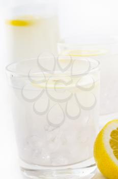 fresh lemonade drink with lemon slice closeup and pitcher carafe