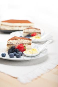 classic Italian tiramisu dessert with berries and custartd pastry cream on side 