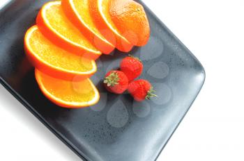 orange & strawberries on a plate on white background