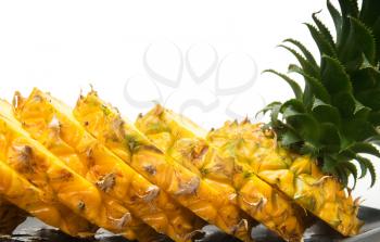 ripe vivid pineapple sliced over white background