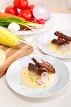 traditional Italian roasted pork ribbs served on polenta bed,corn cream