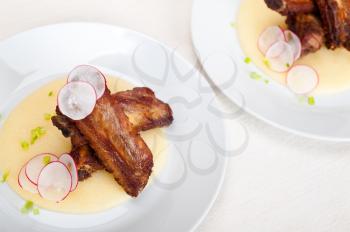 traditional Italian roasted pork ribbs served on polenta bed,corn cream