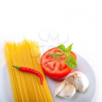Italian spaghetti pasta tomato raw  ingredients basil garlic and red chili pepper