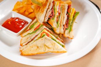 fresh triple decker club sandwich with french fries on side