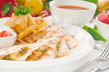 original Mexican quesadilla de pollo with nachos  served with gazpacho soup and watermelon ,with fresh vegetables on background