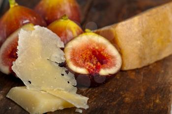 italian pecorino cheese and fresh figs macro closeup over old wood boards