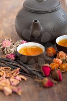 Chinese style herbal floral tea over wood table with raw ingredients