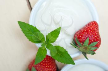 organic Greek yogurt and strawberry over white rustic wood table