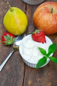 fresh fruits and whole milk yogurt on a rustic wood table