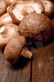 fresh shiitake mushrooms on a rustic wood table 