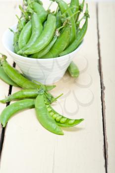 hearthy fresh green peas  over a rustic wood table