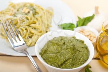 Italian traditional basil pesto pasta ingredients parmesan cheese pine nuts extra virgin olive oil garlic on a rustic table 