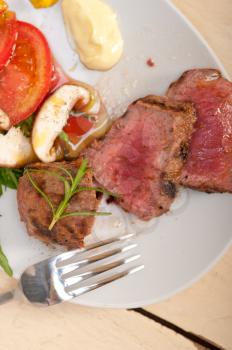 beef filet mignon grilled with fresh vegetables on side ,mushrooms tomato and arugula salad