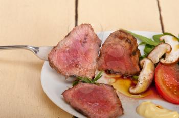 beef filet mignon grilled with fresh vegetables on side ,mushrooms tomato and arugula salad