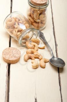 cashew nuts on a glass jar over white rustic wood table 