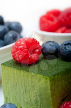 green tea matcha mousse cake with raspberries and blueberries on top