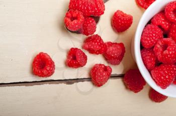 bunch of fresh raspberry on a bowl and white wood rustic  table