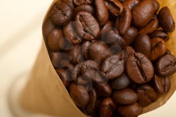 espresso coffee beans on a paper cone cornucopia over white background