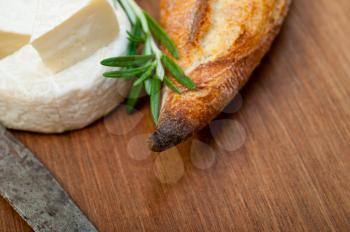 French cheese and fresh  baguette on a wood cutter