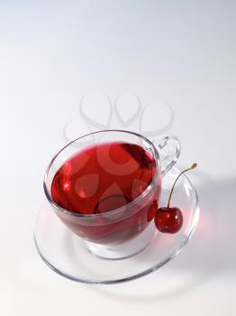 Royalty Free Photo of Herbal Tea With a Cherry in the Saucer