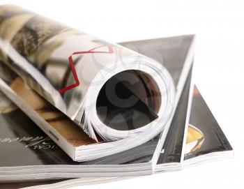 Royalty Free Photo of a Rolled Magazine on Top of a Pile of Magazines