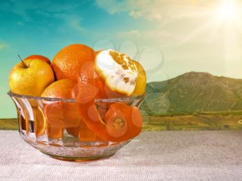 Royalty Free Photo of a Bowl of Fruit in Front of a Landscape