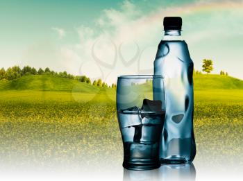 Royalty Free Photo of a Bottle and Glass of Water In Front of a Landscape