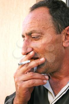 Royalty Free Photo of a Man Smoking a Cigarette