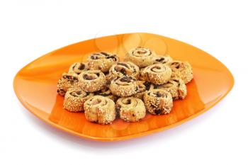 Rusks with sesame seeds and olives on orange plate isolated on white background.