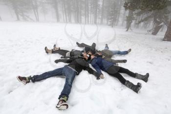 Pelople lying on snow in winter foggy day in Cyprus mountain Troodos.