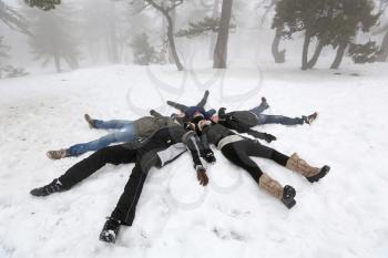 Pelople lying on snow in winter foggy day in Cyprus mountain Troodos.