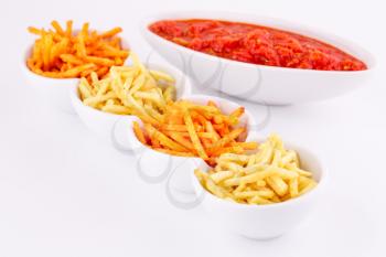 Potato chips and red sauce isolated on gray background.