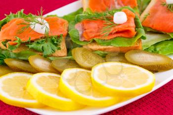 Royalty Free Photo of Smoked Salmon on Bread With Lemons and Pickles