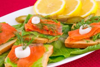 Royalty Free Photo of Smoked Salmon on Bread With Lemons and Pickles