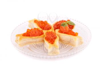 Red caviar in pastries on glass transparent plate.
