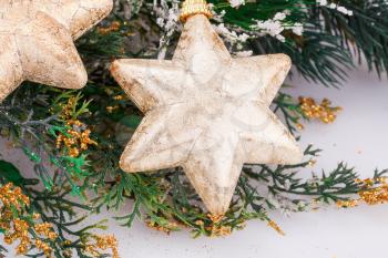 Christmas decoration with yellow stars and fir-tree branch.