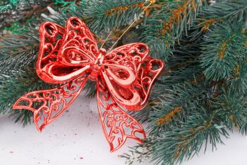Christmas decoration with red ribbon and fir-tree branch.