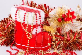 Christmas decoration with Santa's red boot, garland, beads closeup picture.