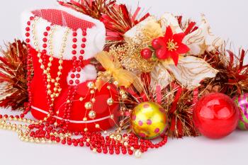 Christmas decoration with Santa's red boot, garland, balls, beads closeup picture.
