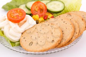 Snack with vegetables and crackers on plate.