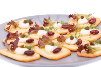 Crackers with red kidney beans and cream on gray plate.