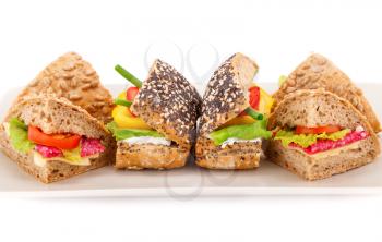 Sandwich with fresh vegetables, salami and cheese on plate.