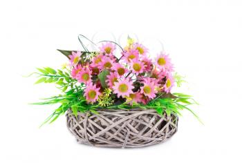 Pink fabric flowers in wicker basket isolated on white background.