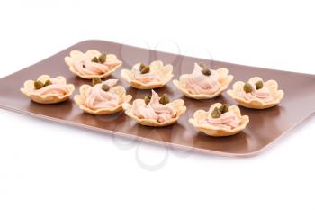 Fish cream and  capers in pastries on brown plate.
