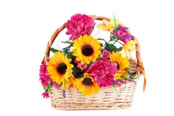 Colorful fabric flowers in wicker basket isolated on white background.