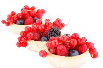 Fresh ripe berries in tartlets isolated on white background.