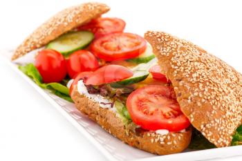 Sandwiches with fresh vegetables and cheese on plate.